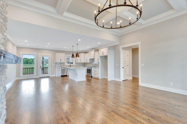 unfurnished living room with a notable chandelier, wood finished floors, baseboards, and coffered ceiling