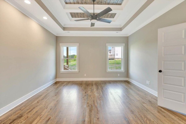 unfurnished room featuring light hardwood / wood-style flooring, ceiling fan, and a raised ceiling