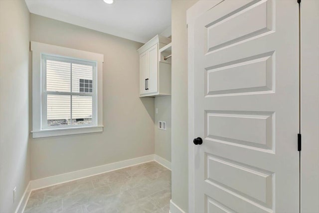 clothes washing area featuring hookup for a washing machine, cabinet space, and baseboards