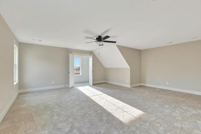 additional living space with ceiling fan, light carpet, and vaulted ceiling