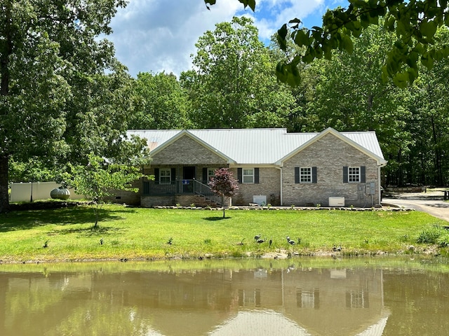 exterior space with a front yard, a water view, and a porch