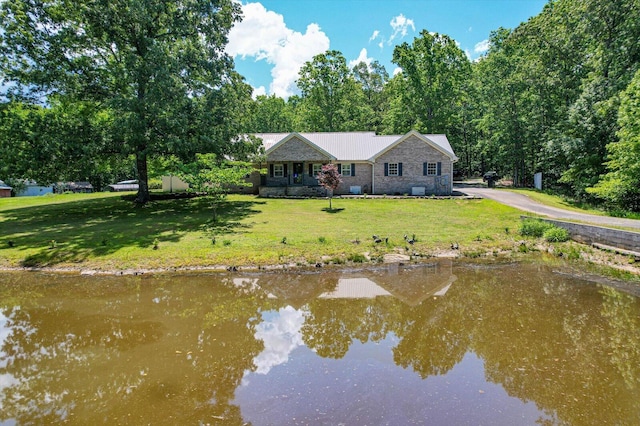 rear view of property with a lawn and a water view