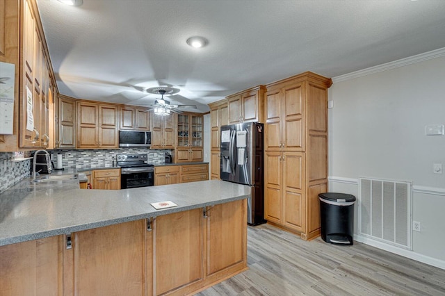 kitchen featuring ornamental molding, appliances with stainless steel finishes, kitchen peninsula, and ceiling fan