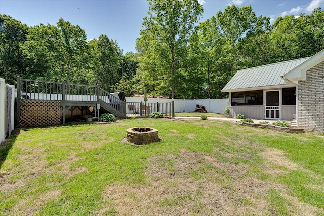 view of yard featuring a wooden deck and an outdoor fire pit