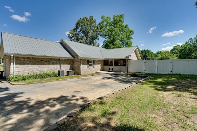 view of front facade with a front lawn and central AC