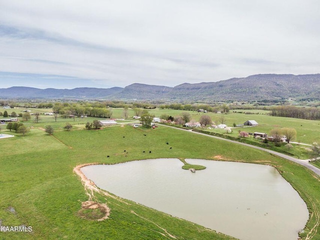 surrounding community with a yard, a rural view, and a water and mountain view