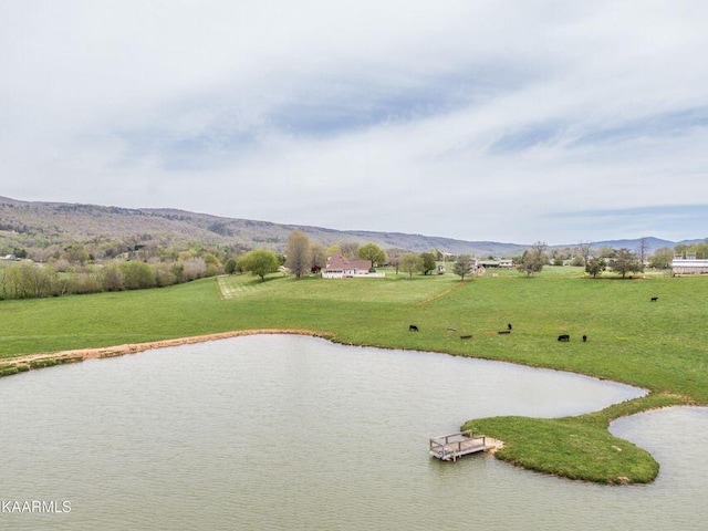 view of property's community with a water and mountain view and a lawn