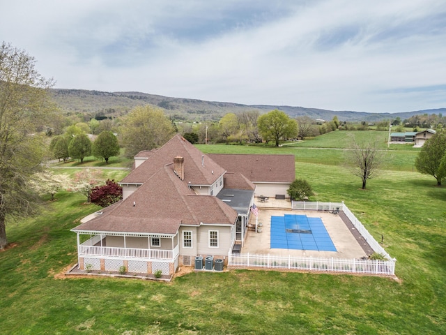 exterior space featuring a fenced in pool, a fenced backyard, a lawn, a patio area, and a mountain view