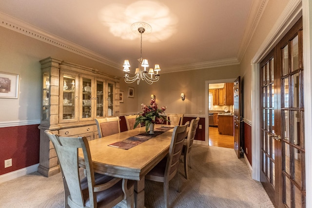 dining room featuring an inviting chandelier, baseboards, and ornamental molding