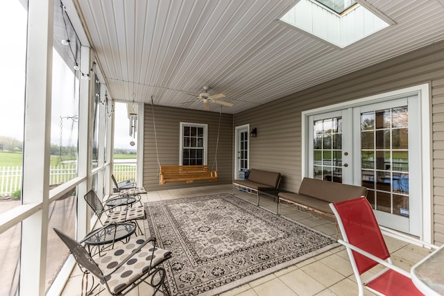 sunroom featuring a skylight, french doors, and ceiling fan