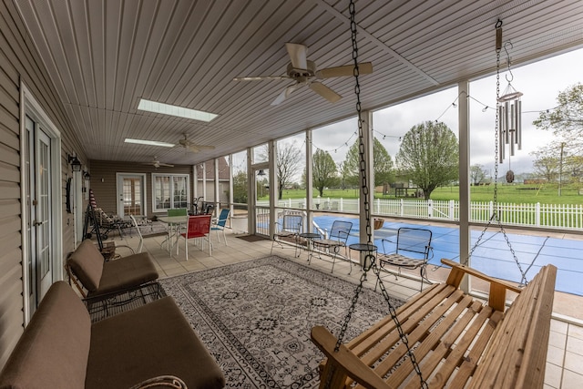 unfurnished sunroom featuring a ceiling fan