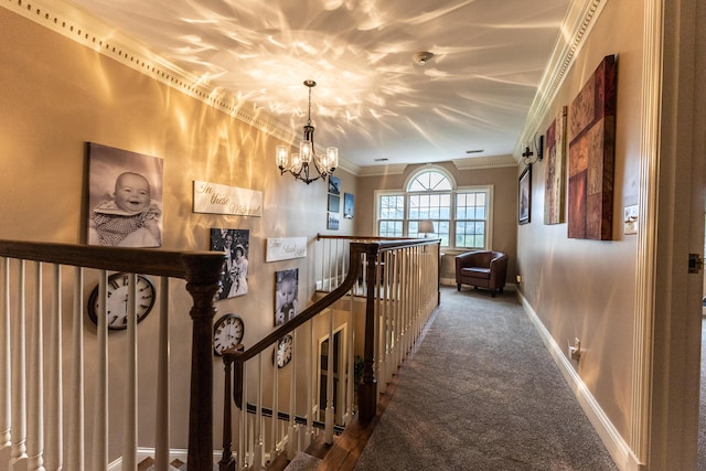 corridor with baseboards, a chandelier, ornamental molding, an upstairs landing, and carpet floors