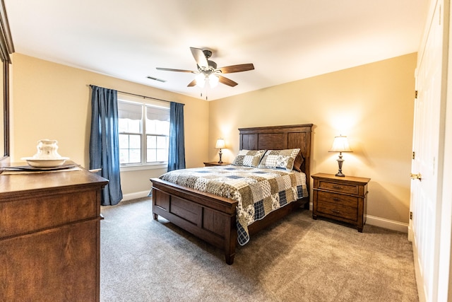 carpeted bedroom with visible vents, baseboards, and ceiling fan