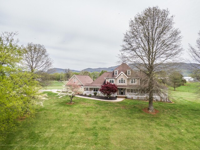 exterior space with a front yard, covered porch, and a mountain view