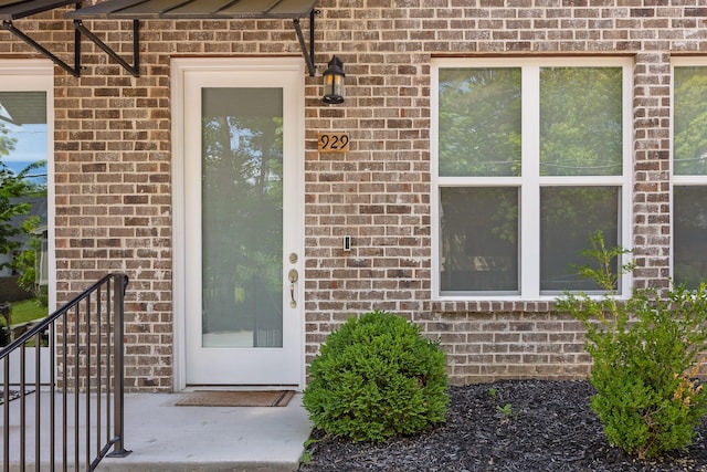 entrance to property featuring brick siding