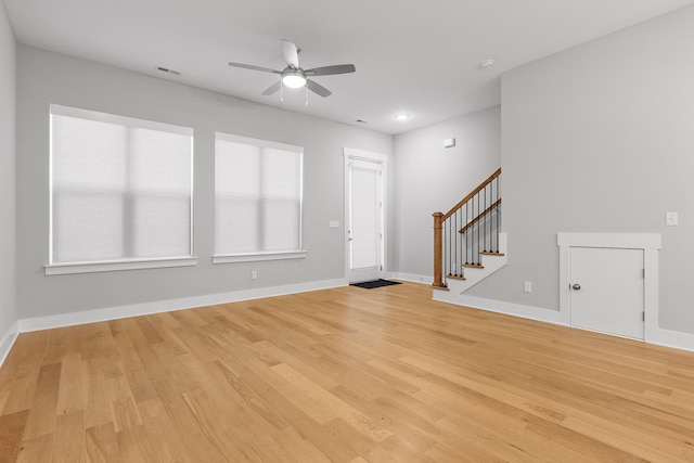 entrance foyer featuring stairs, a ceiling fan, baseboards, visible vents, and light wood-style floors