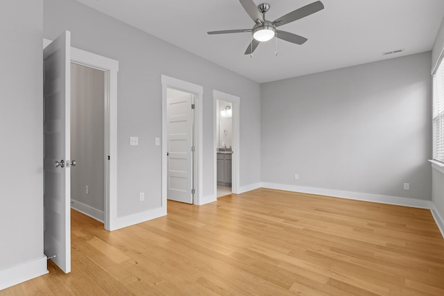 interior space with a ceiling fan, baseboards, light wood-style flooring, and visible vents
