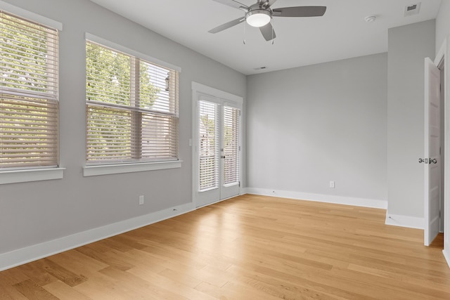 empty room featuring a ceiling fan, baseboards, light wood-style floors, and visible vents