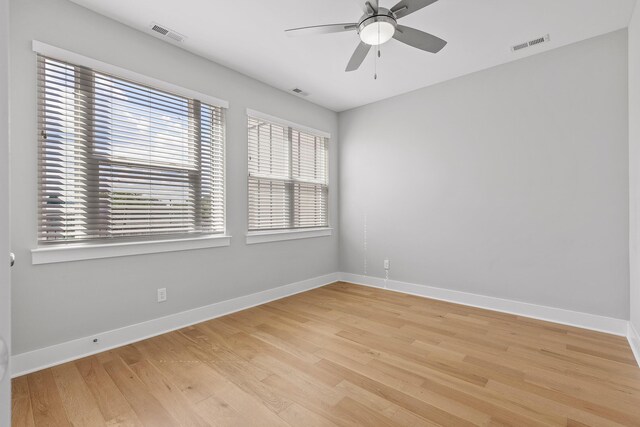 spare room featuring ceiling fan, light hardwood / wood-style floors, and a healthy amount of sunlight