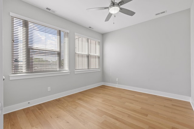 empty room with light wood finished floors, baseboards, visible vents, and ceiling fan