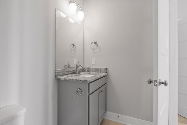 bathroom with baseboards, toilet, and vanity