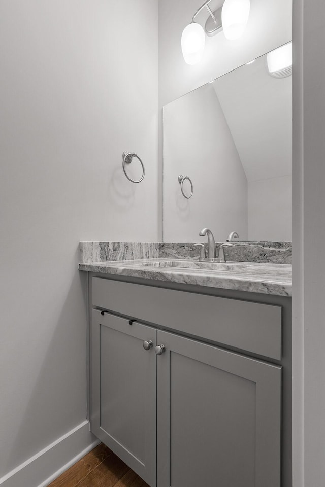 bathroom featuring baseboards, wood finished floors, and vanity