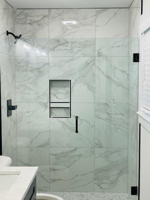 bathroom featuring vanity, toilet, and an enclosed shower