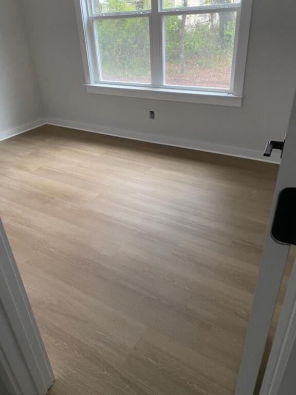 spare room with a healthy amount of sunlight and hardwood / wood-style floors