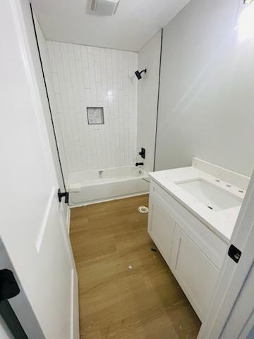 bathroom featuring tiled shower / bath, vanity, and hardwood / wood-style flooring