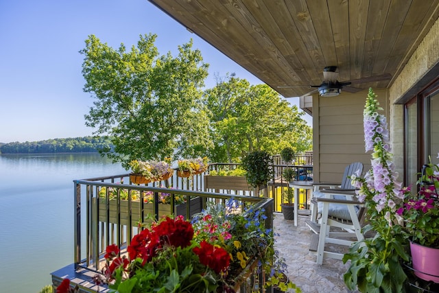 view of patio featuring a balcony, ceiling fan, and a water view