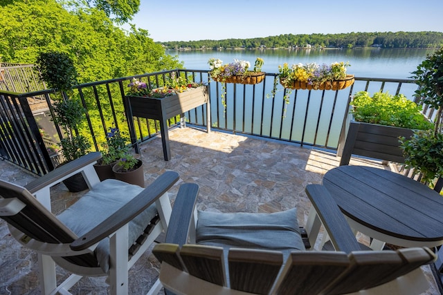 view of patio with a balcony and a water view