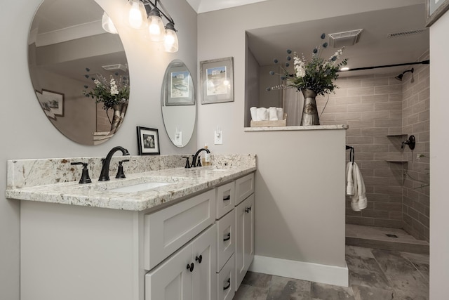 bathroom with tiled shower and vanity