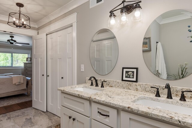 bathroom with crown molding, vanity, ceiling fan with notable chandelier, and wood-type flooring