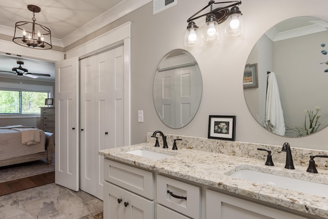 ensuite bathroom featuring double vanity, visible vents, ornamental molding, and a sink
