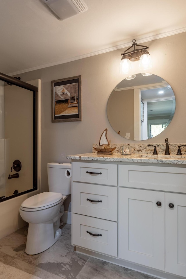 bathroom featuring crown molding, toilet, vanity, bath / shower combo with glass door, and visible vents
