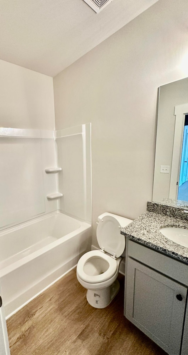 full bathroom featuring vanity, bathtub / shower combination, toilet, and wood-type flooring