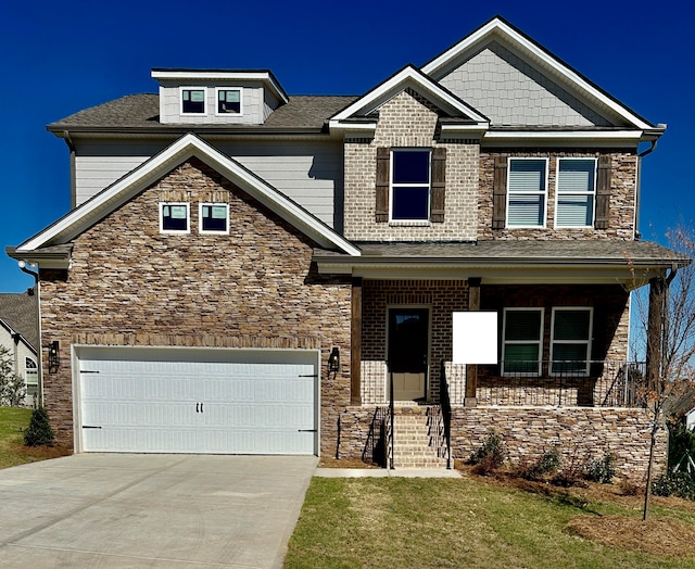 craftsman inspired home with a front yard, a garage, and a porch