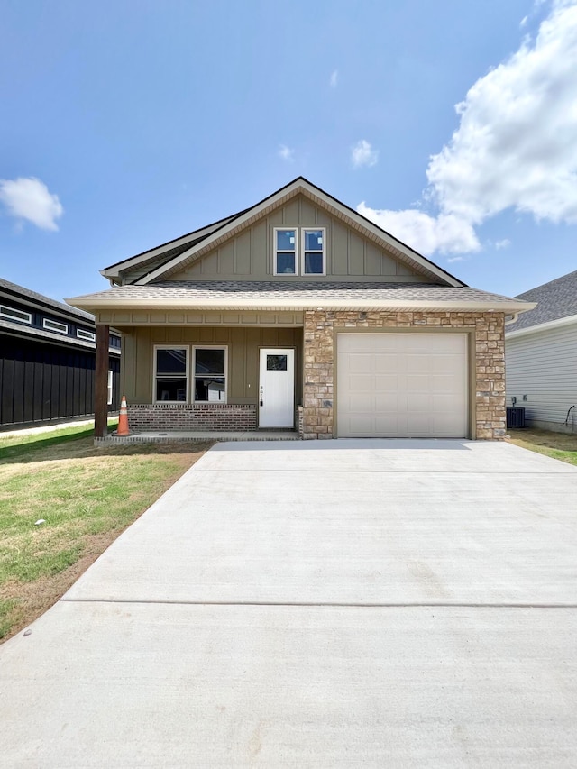 view of front of property with a garage, covered porch, and a front yard