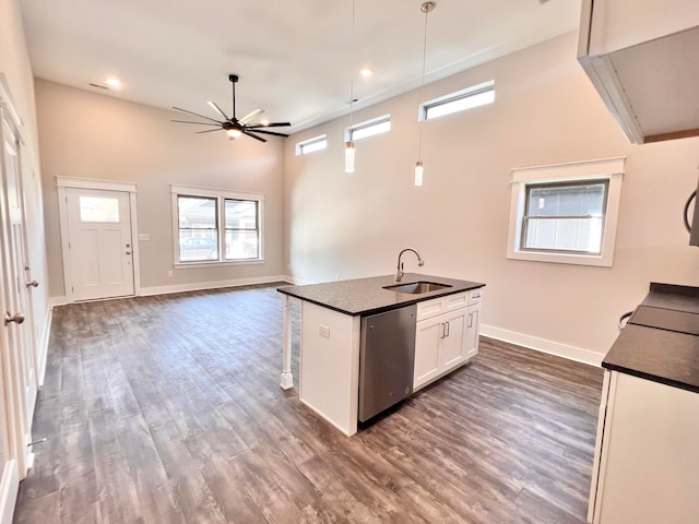 kitchen with white cabinets, dishwasher, sink, ceiling fan, and a kitchen island with sink