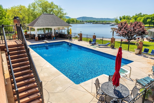 view of swimming pool featuring a patio area, a water and mountain view, and a gazebo