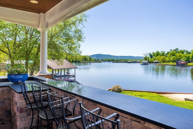 exterior space featuring a water and mountain view, a gazebo, and exterior bar