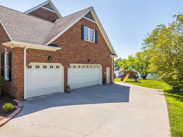 view of property exterior featuring a garage, a playground, and a yard