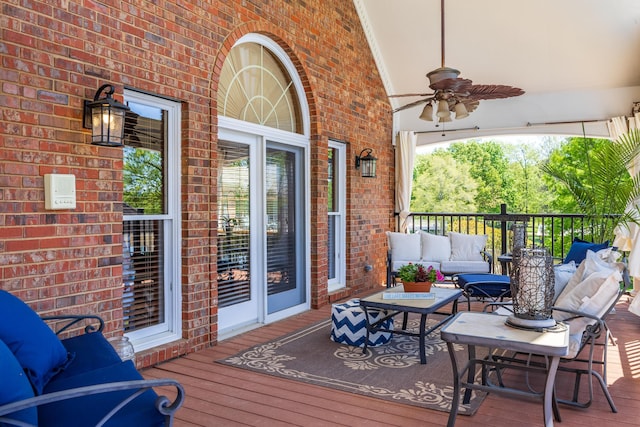 wooden deck with ceiling fan and an outdoor living space