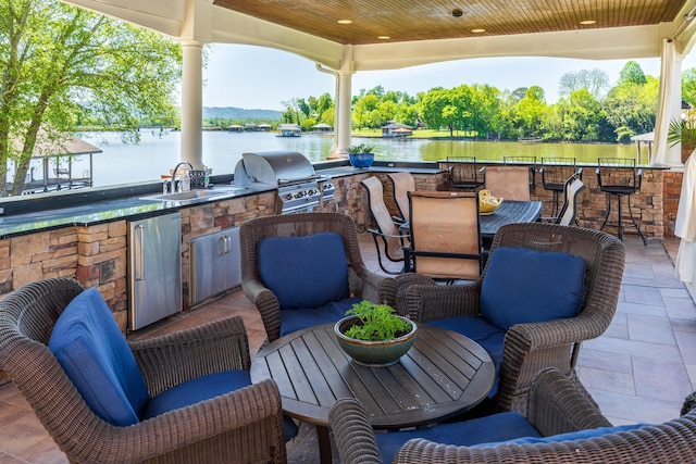 view of patio / terrace featuring exterior kitchen, a water view, area for grilling, and sink