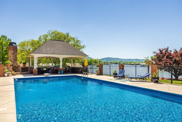 view of swimming pool with a patio area, a gazebo, and a mountain view