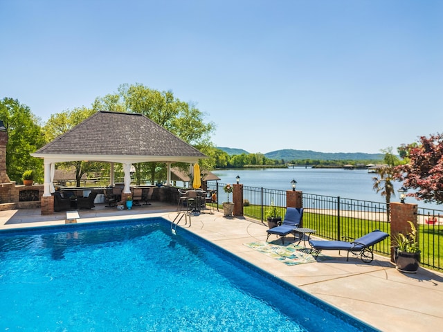 view of pool with a patio area, a water and mountain view, and a gazebo