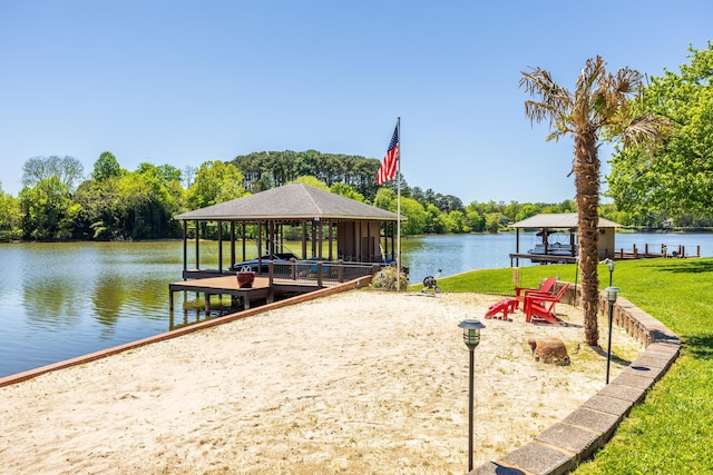 view of dock with a water view, a yard, and a gazebo