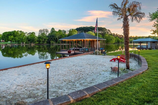 view of dock with a water view and a yard