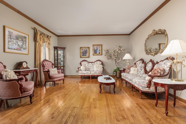 living area with light hardwood / wood-style floors and ornamental molding