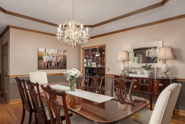 dining space featuring ornamental molding, hardwood / wood-style floors, and a chandelier